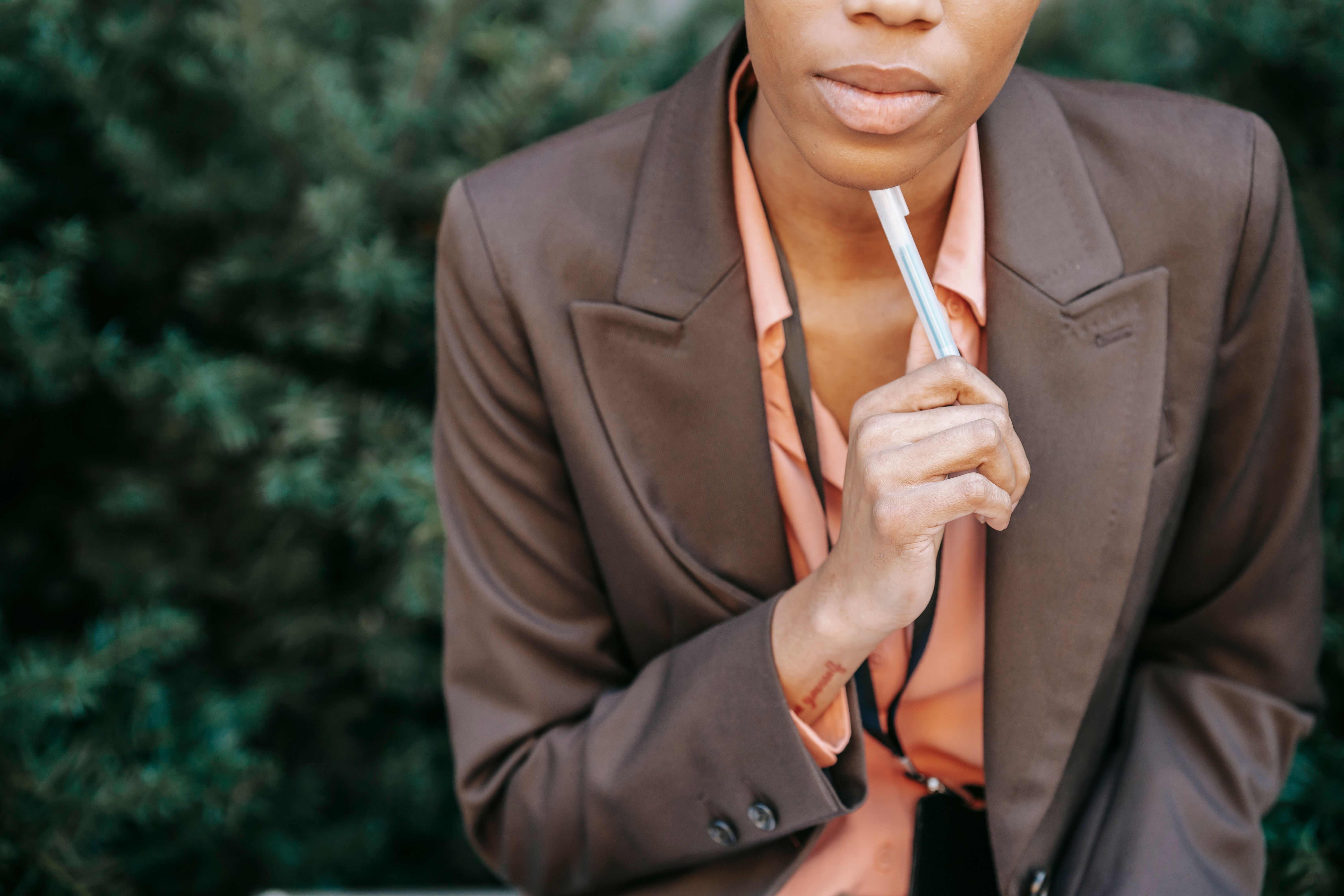 Confident businesswoman in a thoughtful pose with pen, symbolizing decision-making and strategy